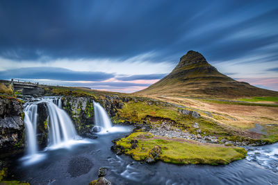 Scenic view of waterfall against sky