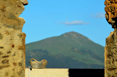 View of a mountain between two stone houses 