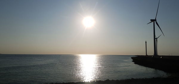 Scenic view of sea against bright sun