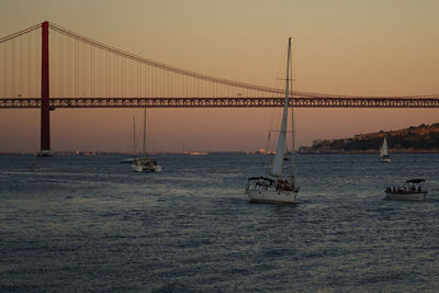 Suspension bridge over sea against clear sky