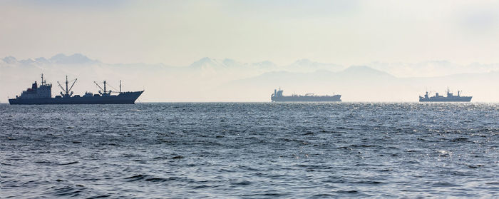 The large fishing vessel on the background of hills and volcanoes