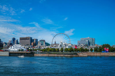 City by river against blue sky