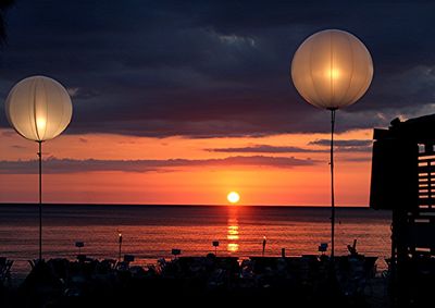 Street light and sea against sky during sunset