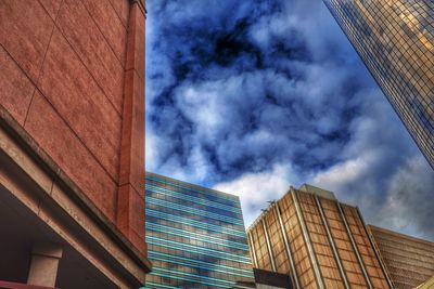 Low angle view of modern building against cloudy sky