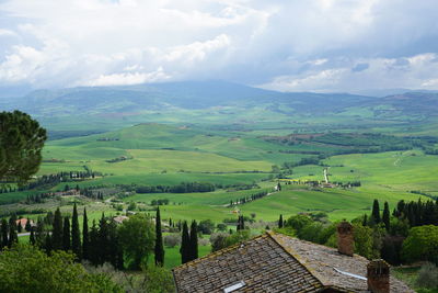 Scenic view of green landscape and mountains against sky