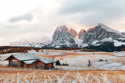 Built structure on snow covered landscape against sky