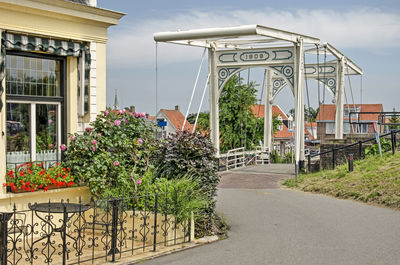 View of street by building against cloudy sky