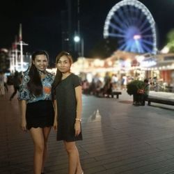 Woman in illuminated city at night