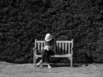 Woman reading book while sitting on bench