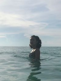 Man swimming in sea against sky