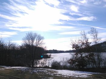 Reflection of trees in water against sky