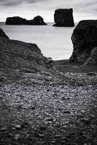 Rock formation on beach against sky