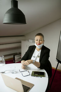 Smiling businesswoman wearing face mask looking at camera