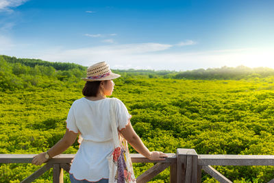 Rear view of woman looking at landscape against sky