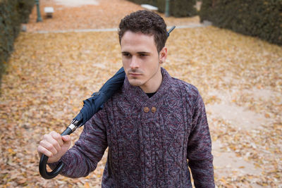 High angle view of man holding umbrella while standing on field at park