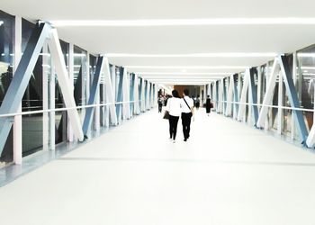 Rear view of people walking on footbridge