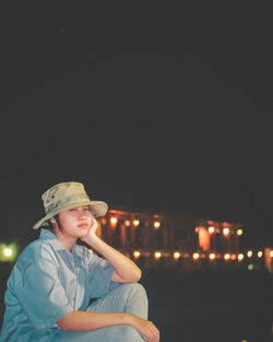 Portrait of smiling girl wearing hat sitting outdoors