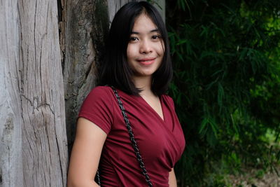 Beautiful young woman standing against plants