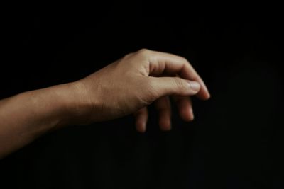 Close-up of hand holding glass over white background