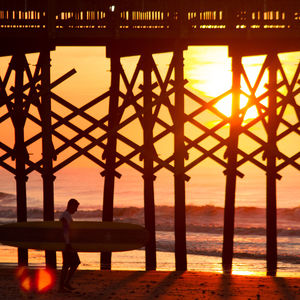 Silhouette man looking at sea against sky during sunset