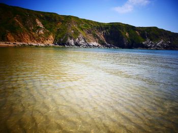 Scenic view of sea and mountains against sky