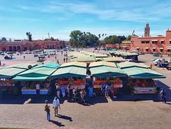 People walking on street market against sky