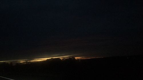 Silhouette landscape against sky at night