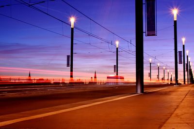 Light trails on road against sky at sunset