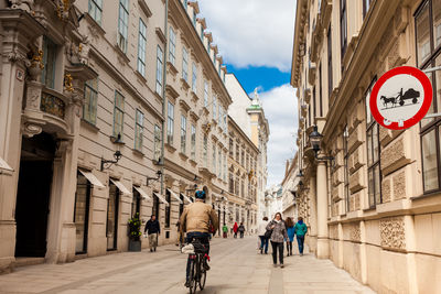 People walking on road amidst buildings in city