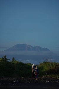 People on mountain against sky