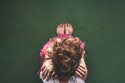 Directly above shot of sad woman sitting on floor