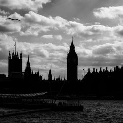 Silhouette big ben against cloudy sky