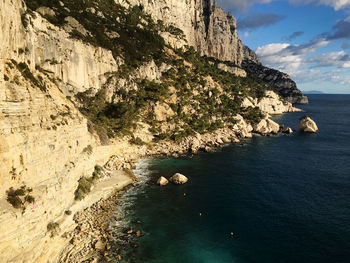 Rock formations by sea against sky