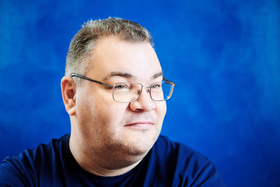 Close-up of young man against blue background
