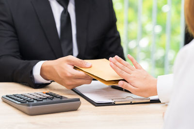 Midsection of man holding hands on table