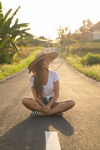 Rear view of woman wearing hat standing on field