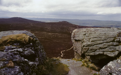 Rock formations by mountain against sky