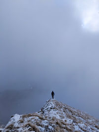 Man on snowcapped mountain against sky