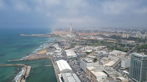 High angle view of city by sea against sky