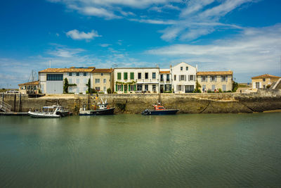 View of buildings by sea against sky