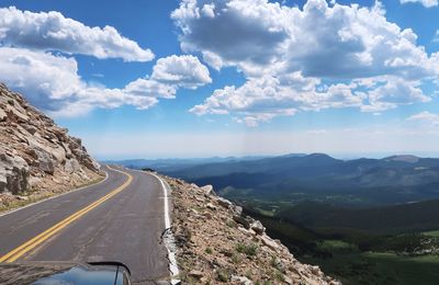 Road leading towards mountains against sky