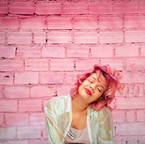 Woman with dyed hair against pink wall