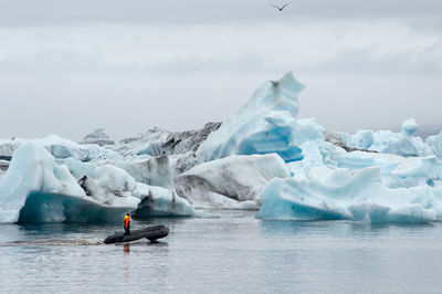 Man surfing in frozen sea against sky