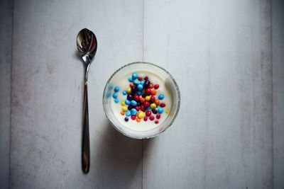 Directly above shot of colorful candies in bowl on table