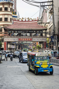 Vehicles on road by buildings in city