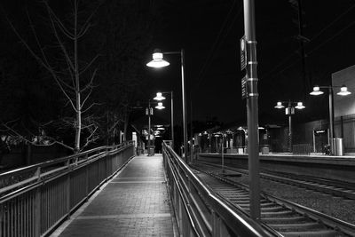 Illuminated railroad tracks against sky at night