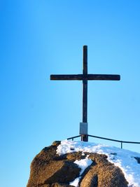 Low angle view of cross against clear blue sky