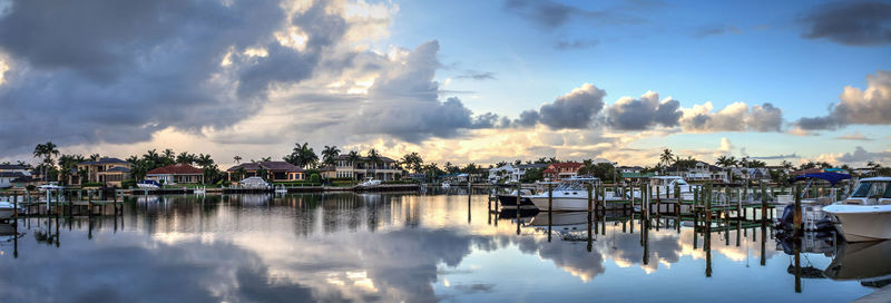 Panoramic view of boats moored in harbor against sky