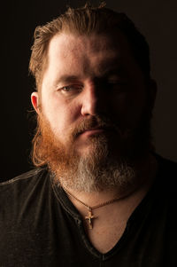 Close-up portrait of man against black background