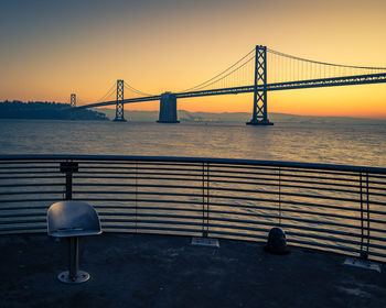 Bay bridge against clear sky at sunrise